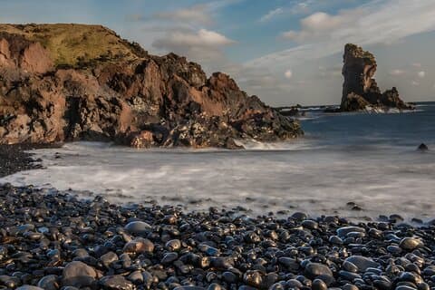 Explore the hauntingly beautiful black pebble beach, filled with lava rock formations and the remnants of a shipwreck