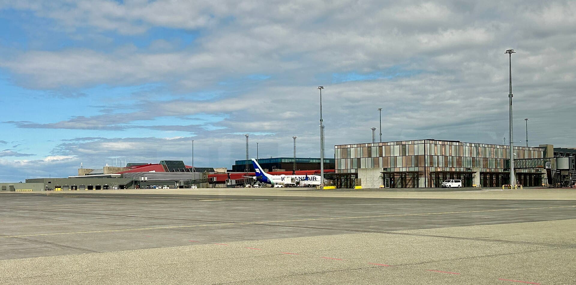 Keflavík International Airport terminal seen from the tarmac, with an Icelandair jet at the gate