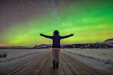 A happy guest welcoming the dancing Northern Lights