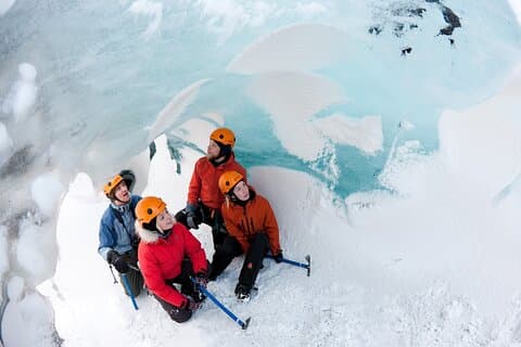 Equipped with crampons and safety gear, guests explore crevasses and blue ice formations on a guided Sólheimajökull glacier hike in South Coast Iceland