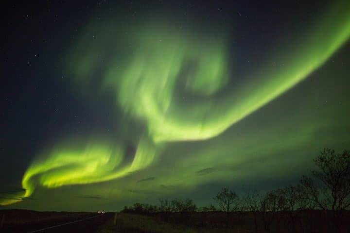 Aurora Borealis, known as the Northern Lights, shimmers across the night sky.